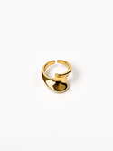 A polished gold-plated metal ring with a unique, organic wavy shape, photographed on a clean white background.