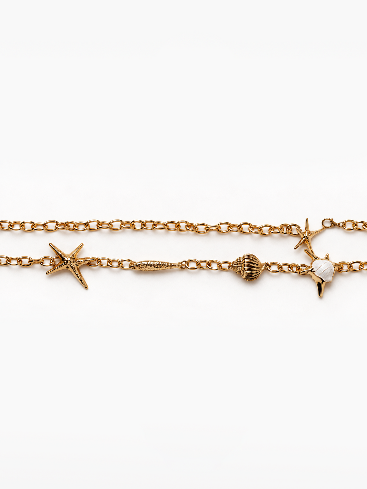 A gold-toned chain belt featuring seashell and starfish charms, displayed horizontally against a clean white background.