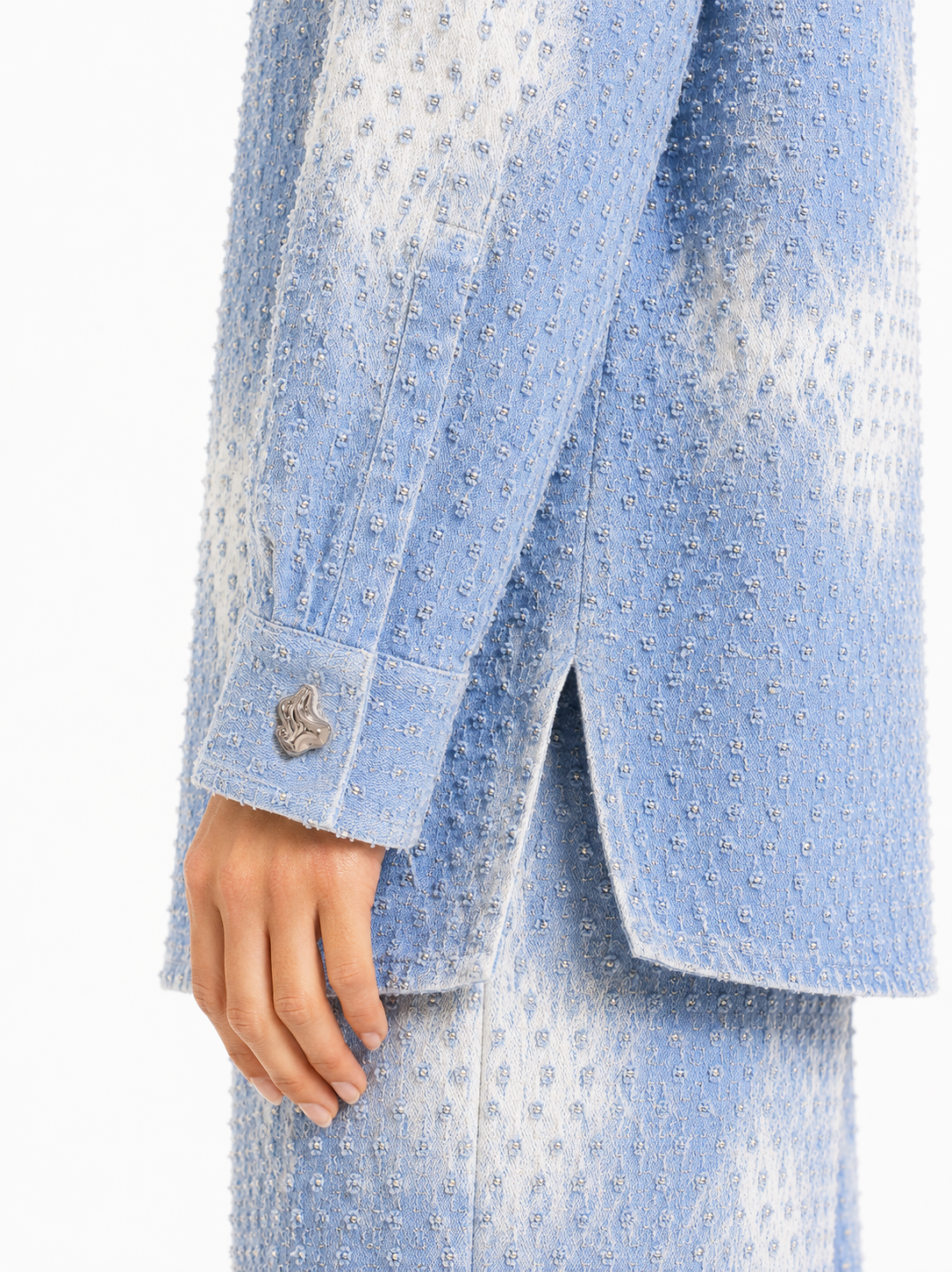 Close-up pf the Amelie light blue shirt highlighting the textured fabric, long sleeve and clean tailored detailing.
